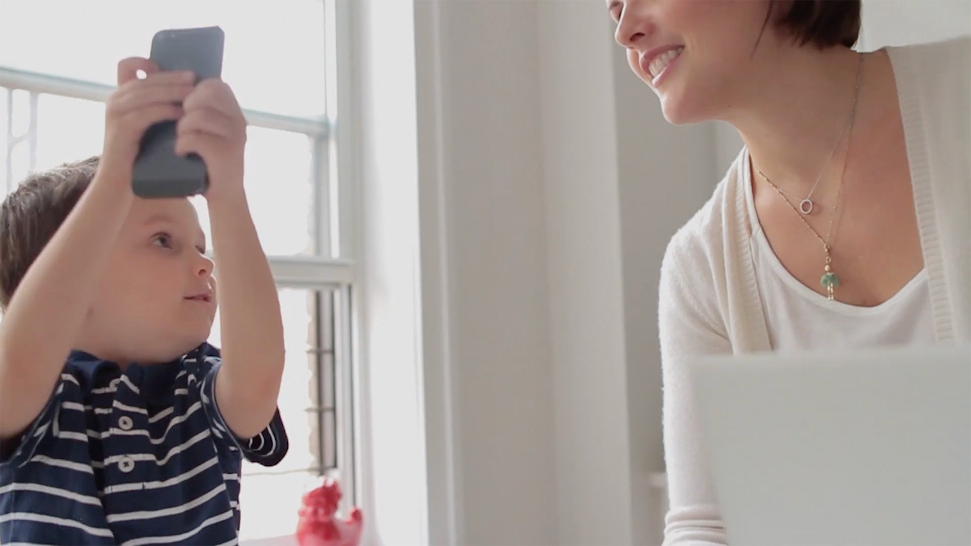 little boy showing his mother one of Sago Mini's app on a mobile phone